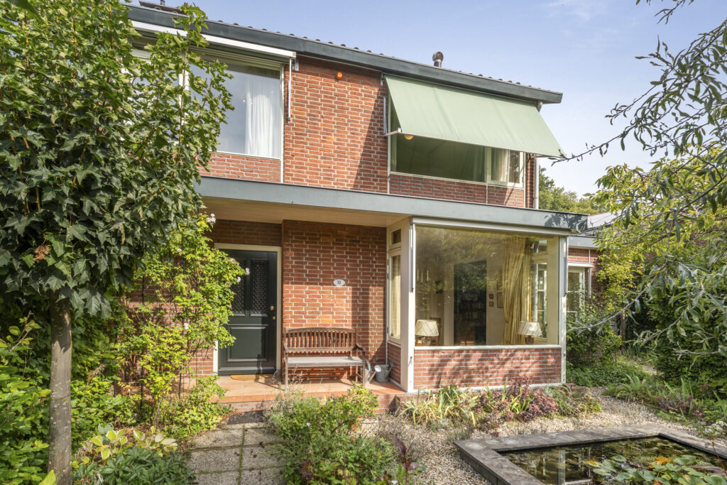 Red brick house with garden and pond