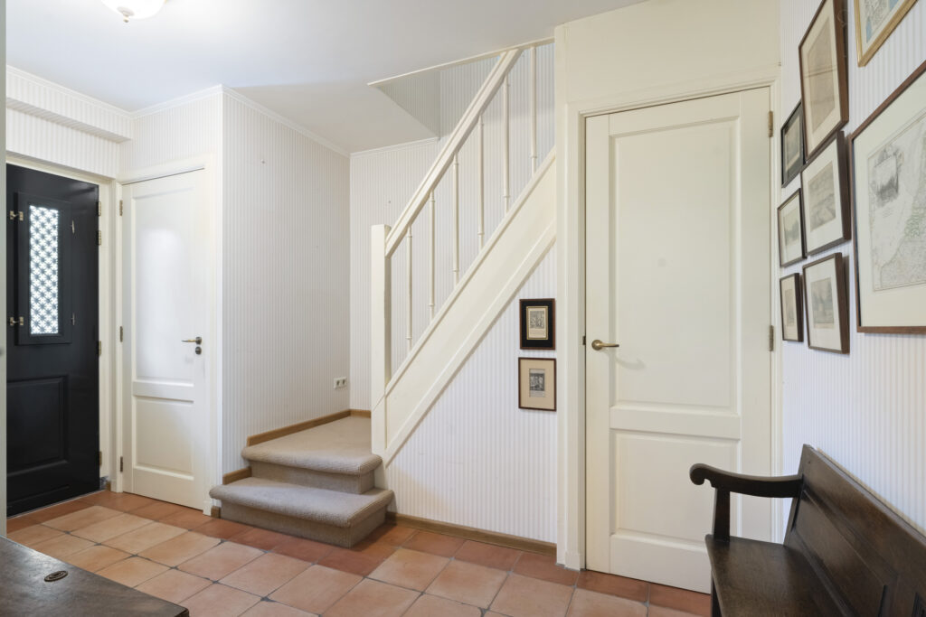 Cozy hallway with staircase and framed pictures