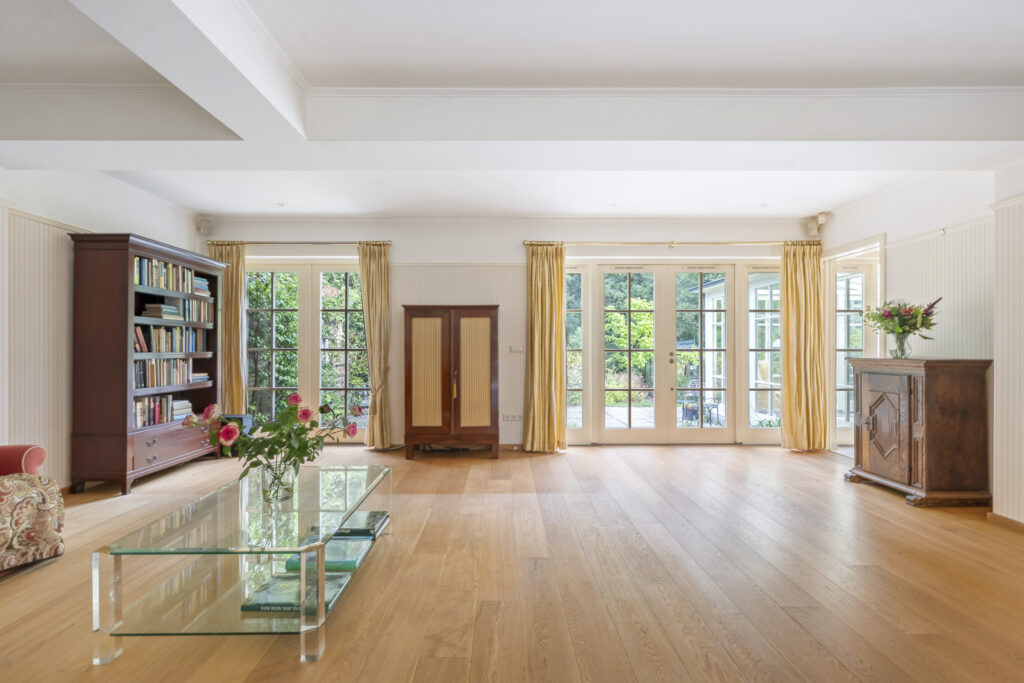 Spacious living room with bookshelves and glass table.