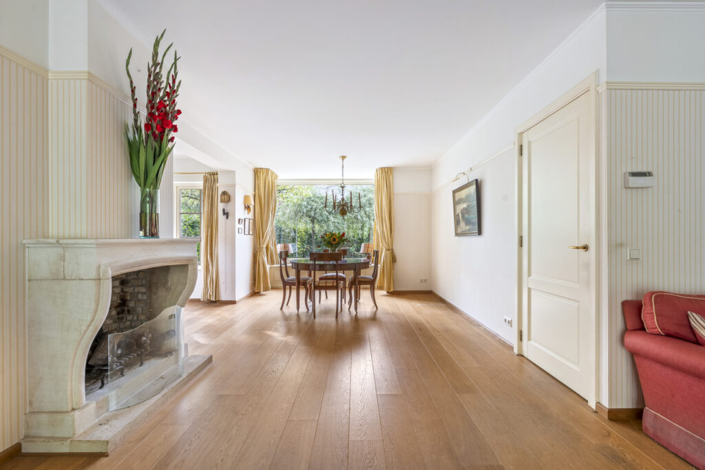 Elegant dining room with fireplace and large window.