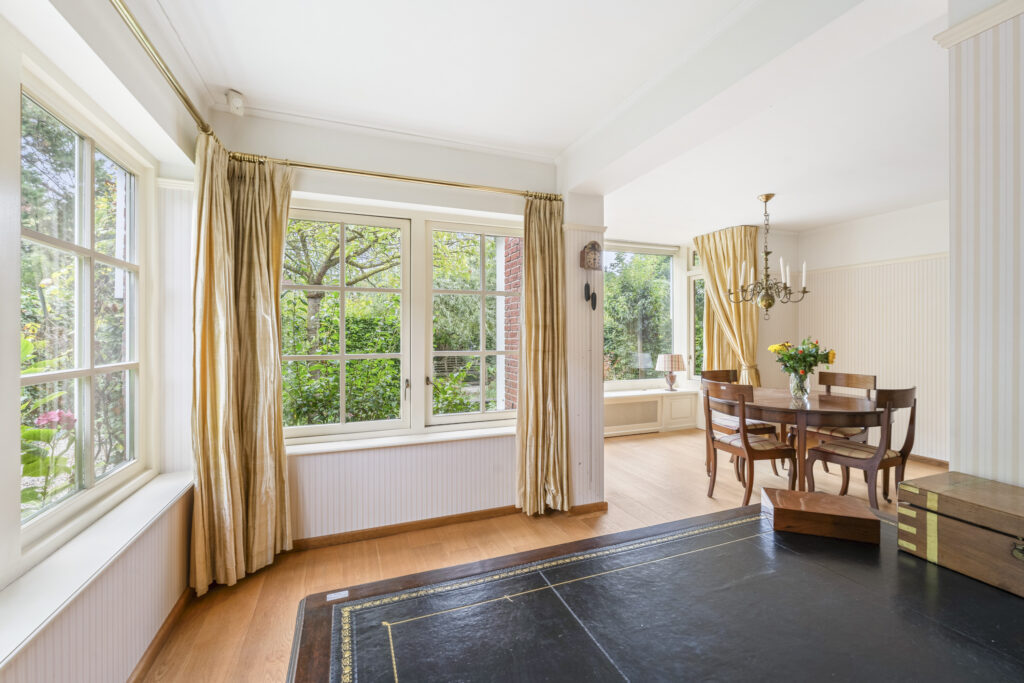 Bright dining room with large windows and table.