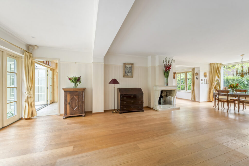 Spacious living room with wooden floors and dining area.
