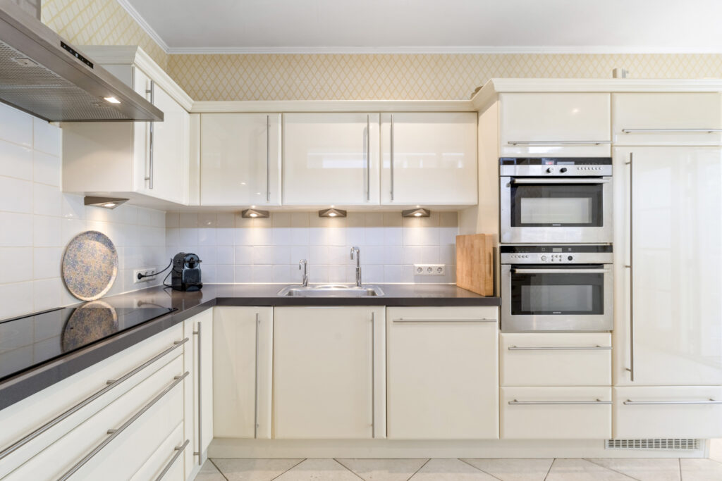 Modern kitchen with white cabinets and appliances.