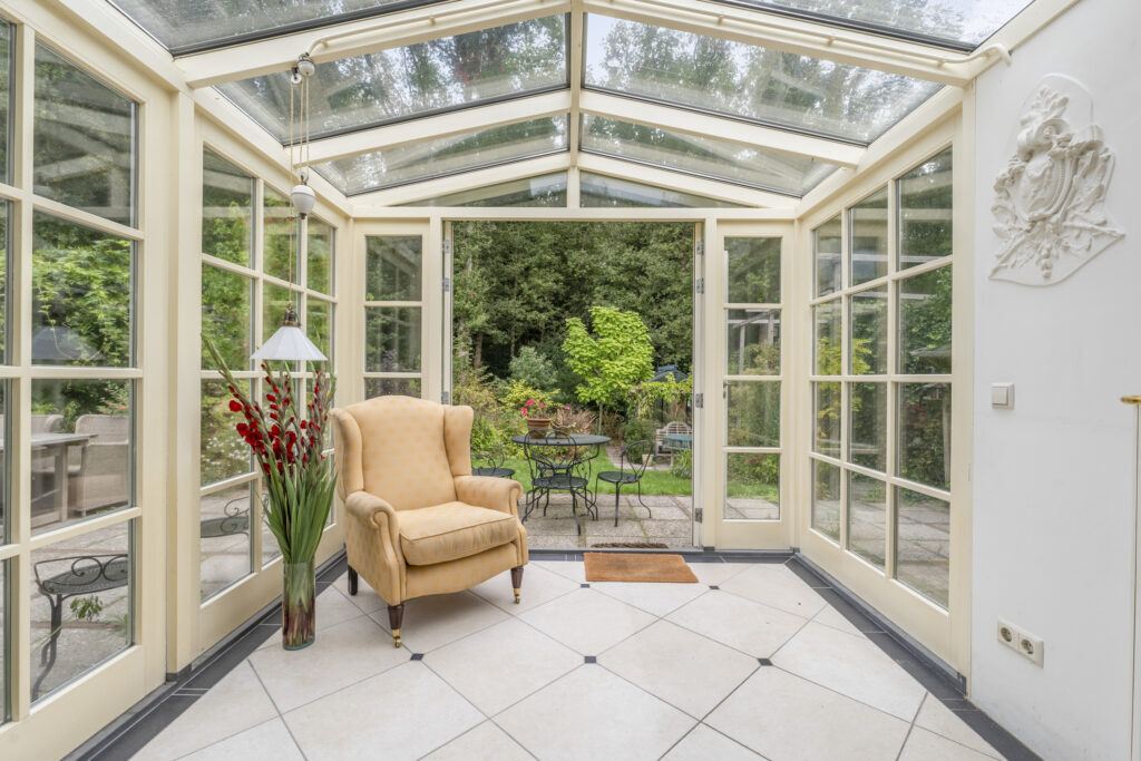 Bright sunroom with armchair and garden view.