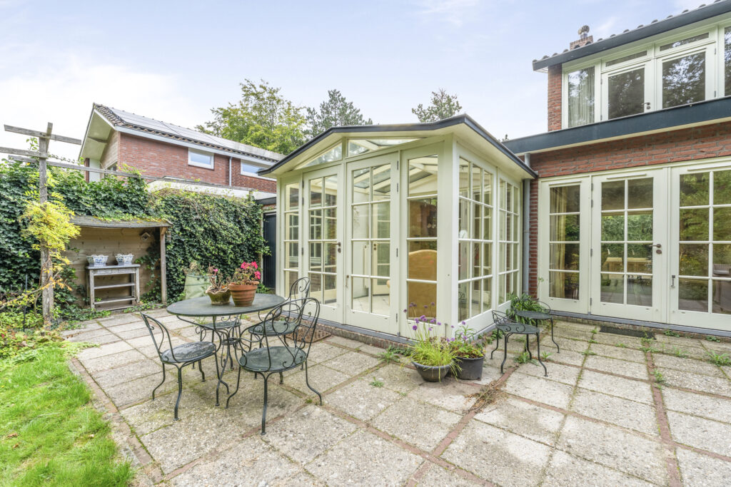 Backyard view with greenhouse and patio furniture