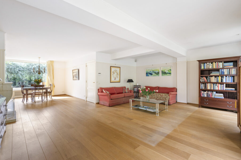 Spacious living room with wooden floors and sofa.