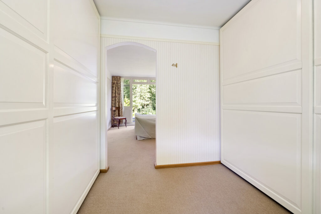 Spacious hallway leading to bedroom with garden view.