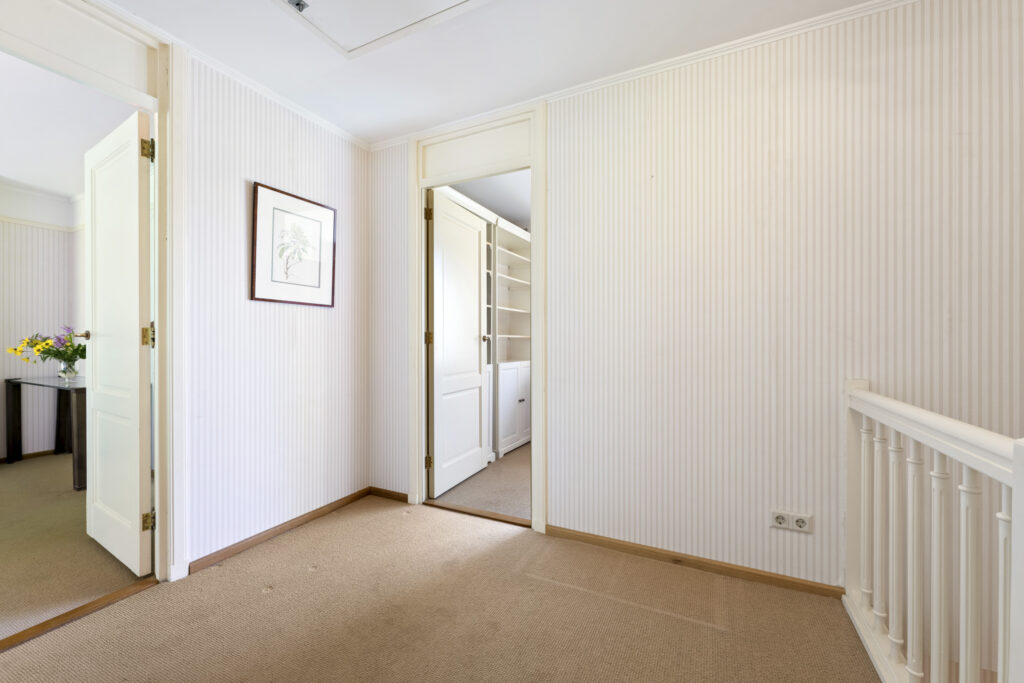 Cozy hallway with open doors and wall art.