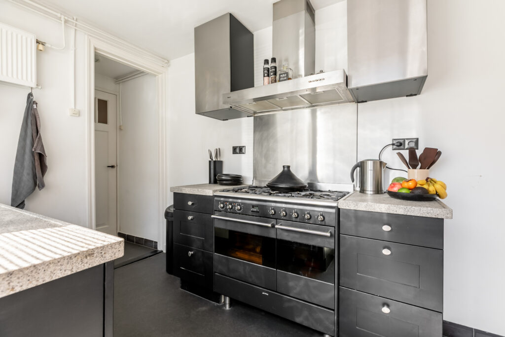 Modern kitchen with stainless steel appliances and fruit.