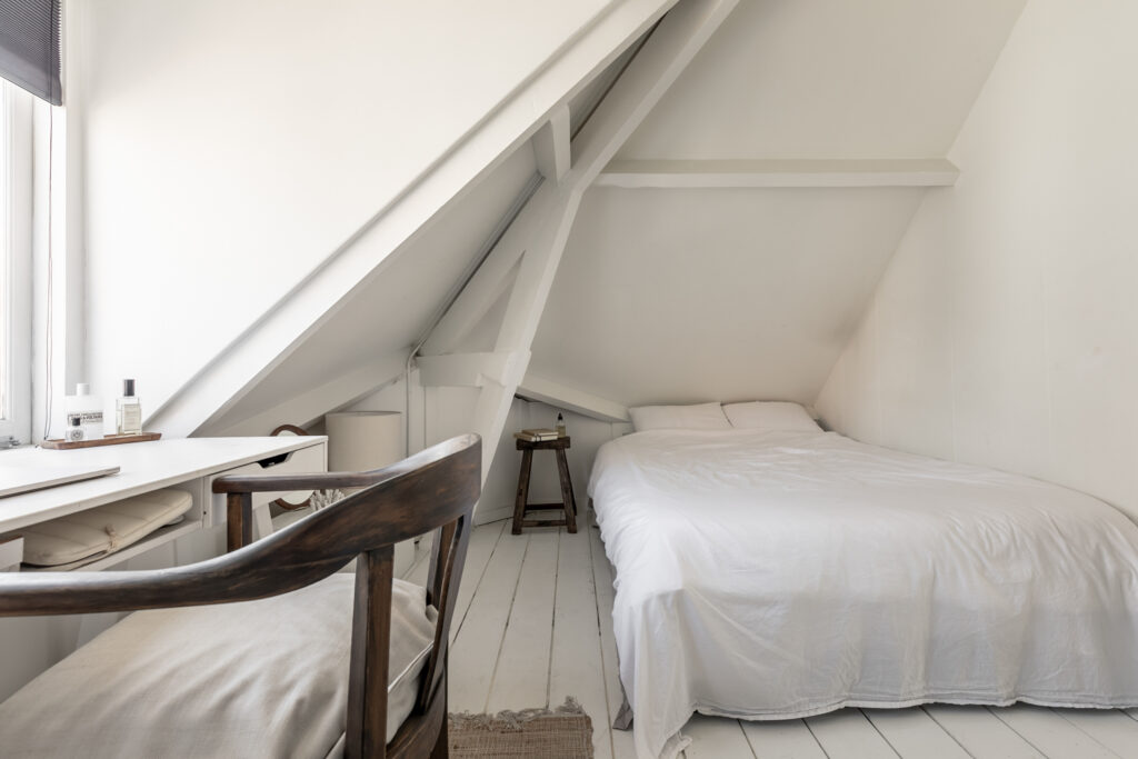 Cozy attic bedroom with wooden chair desk