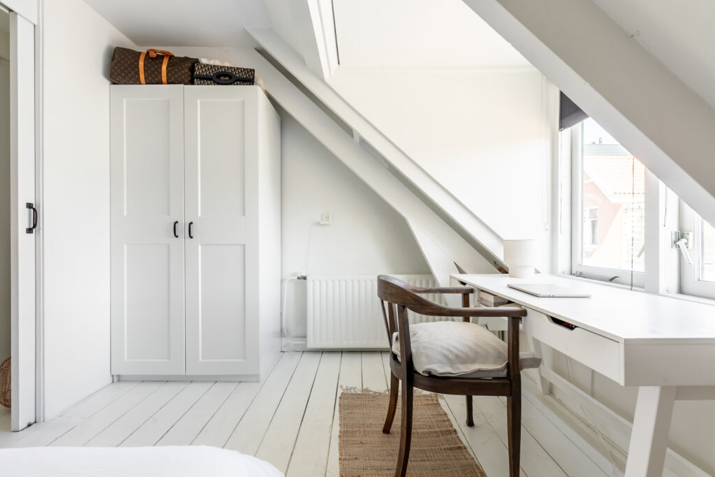 Bright attic room with desk and chair.