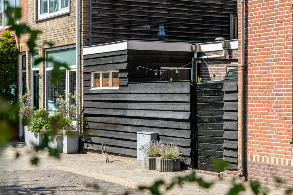 Backyard with wooden fence and small windows.