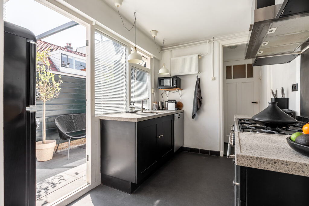 Modern kitchen with black cabinets and patio access.