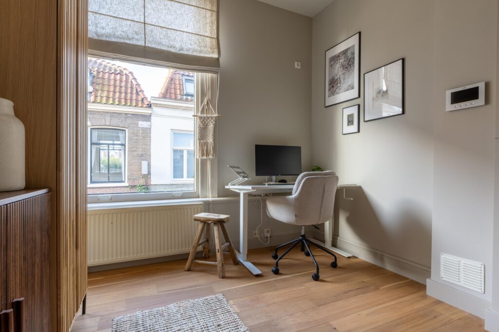 Cozy home office with desk and window view.