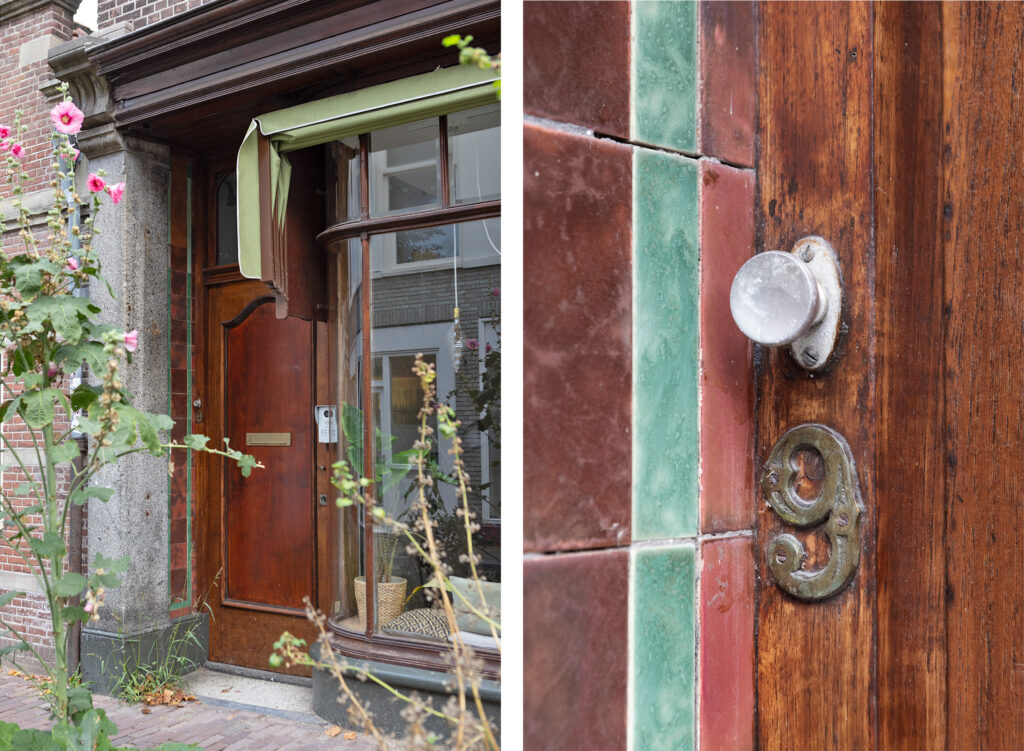 Rustic wooden house door with green tiles and number.