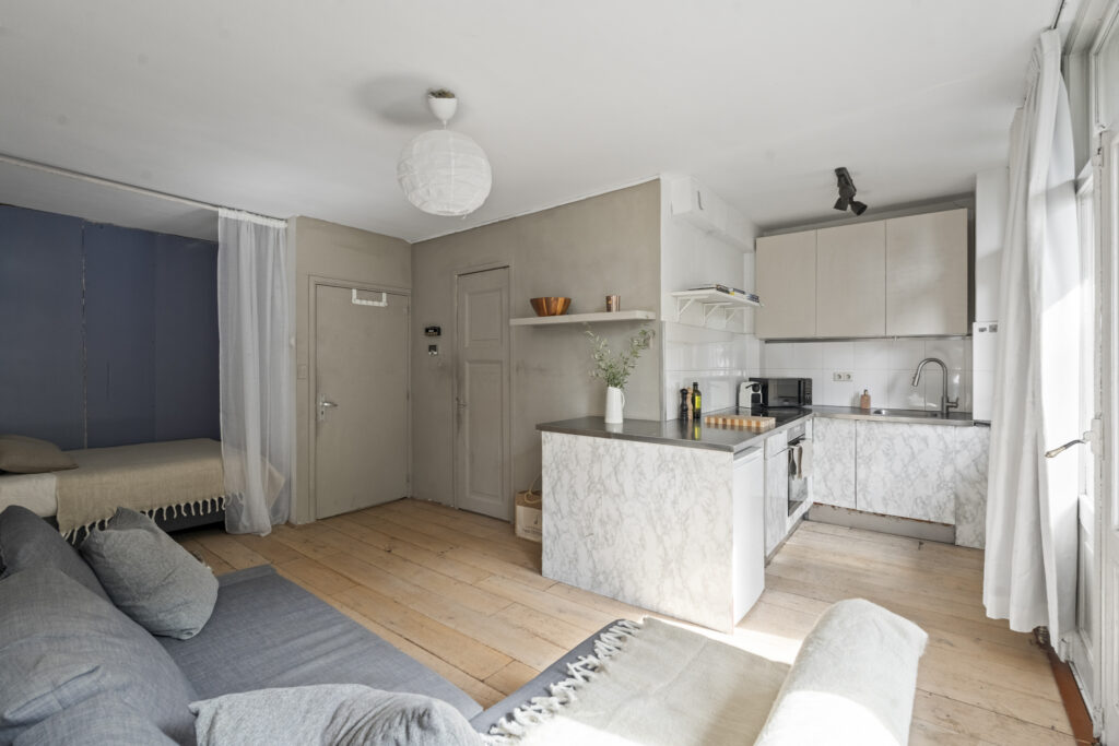 Modern studio apartment with kitchen and living area.