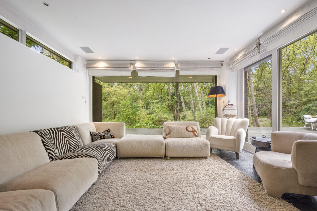 Modern living room with large windows and carpet