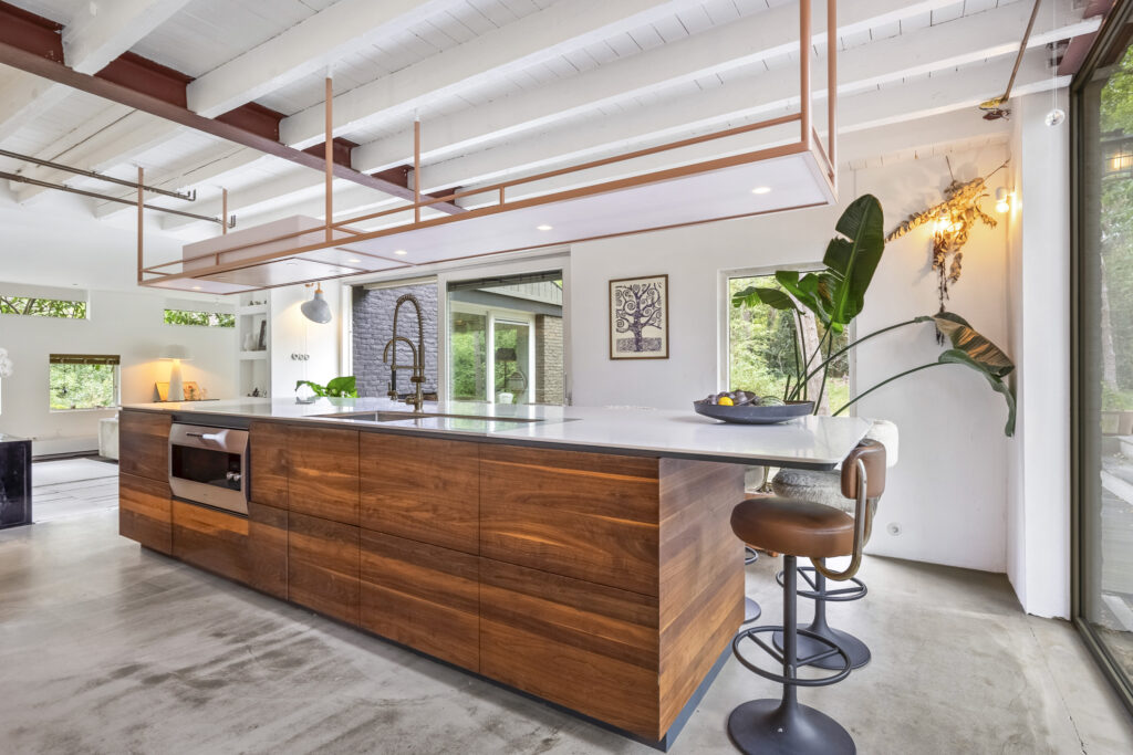 Modern kitchen with wooden island and bar stools.
