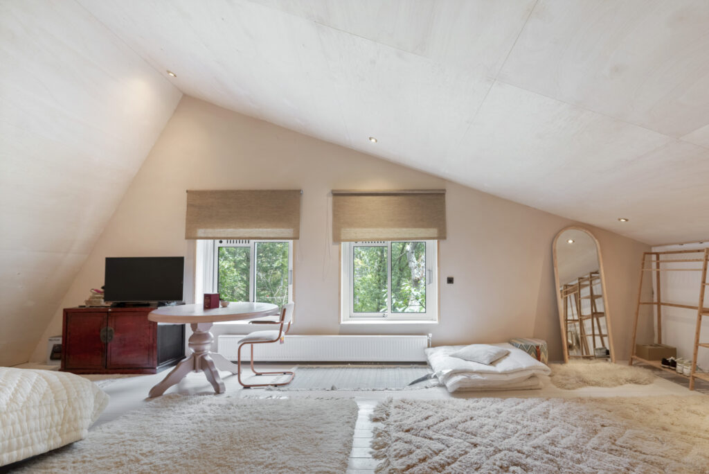 Cozy attic room with window and furniture.