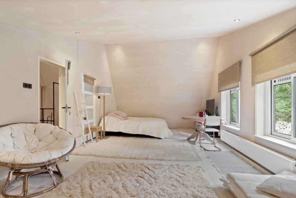 Cozy bedroom with modern decor and large windows.