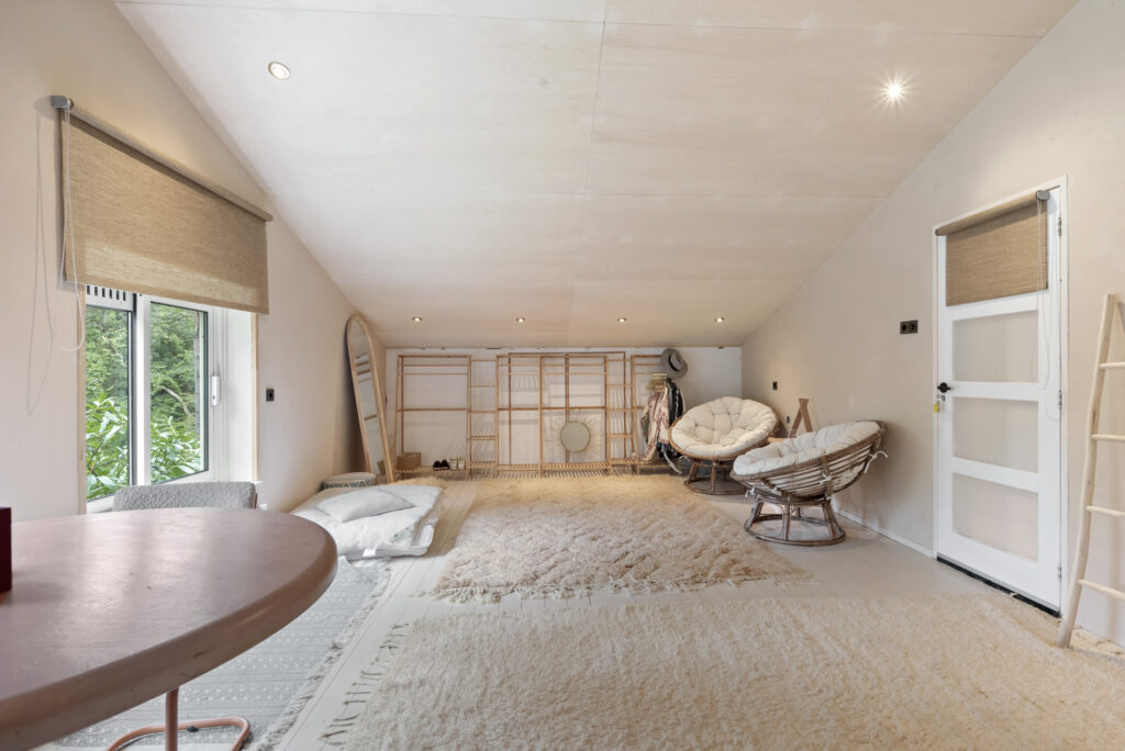 Cozy attic with rugs and seating.