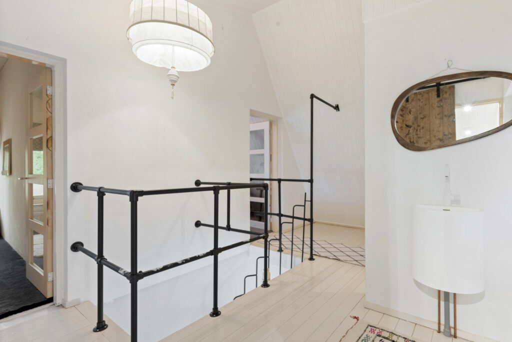 Bright hallway with railing and mirror.