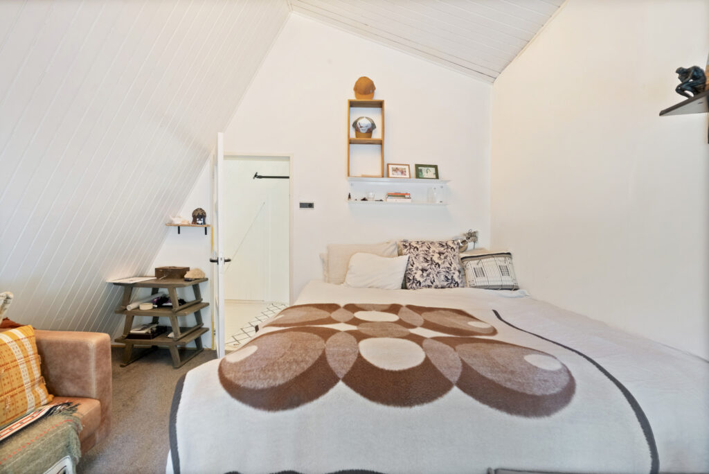 Cozy attic bedroom with geometric bedspread