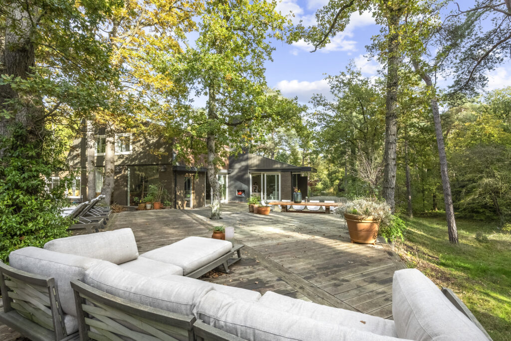 Spacious deck surrounded by lush trees and greenery.