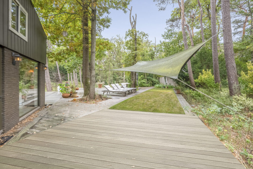 Spacious backyard with decking and trees.