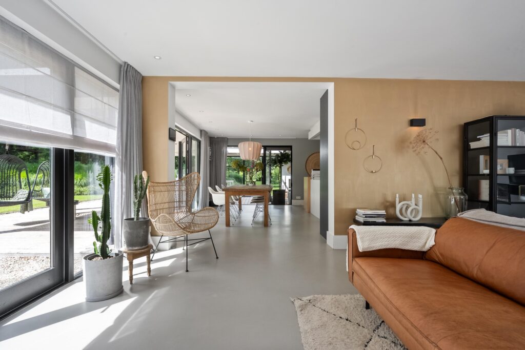 Modern living room with large windows and plants.