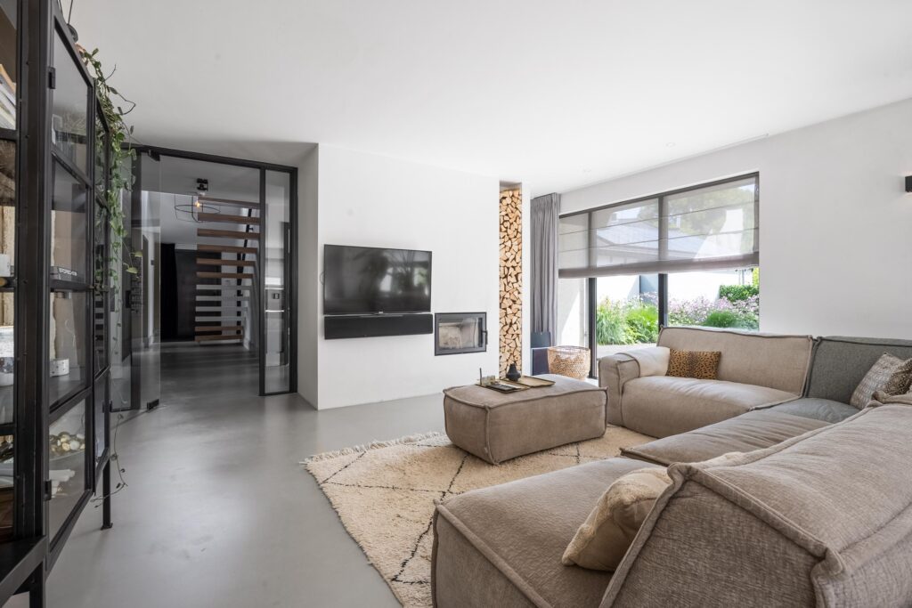 Modern living room with beige sofas and fireplace.