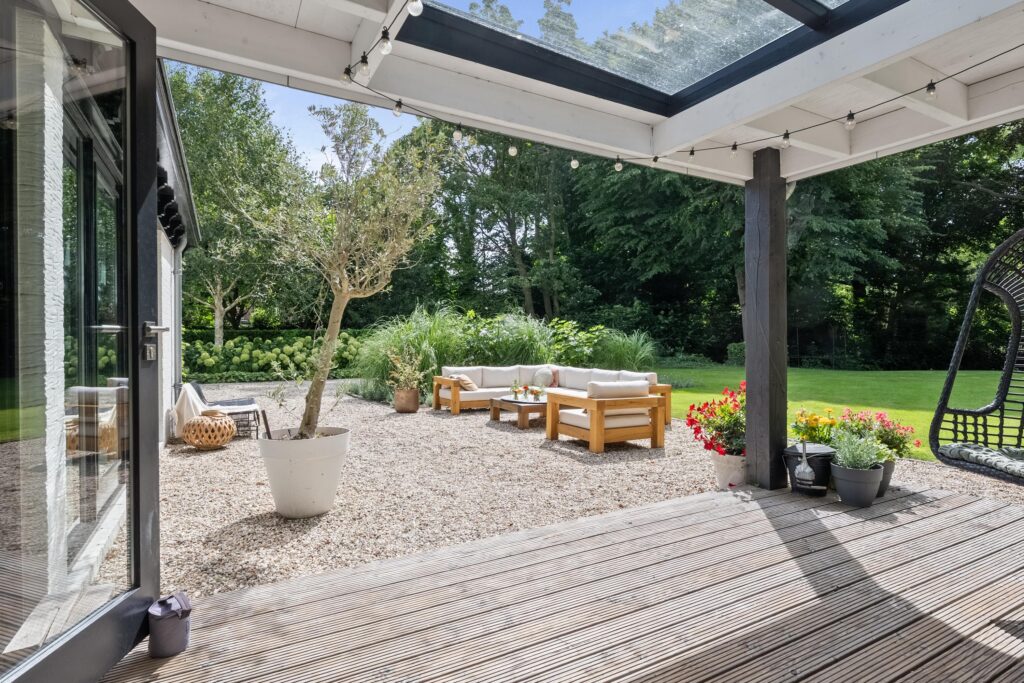 Outdoor patio with seating and plants in garden.