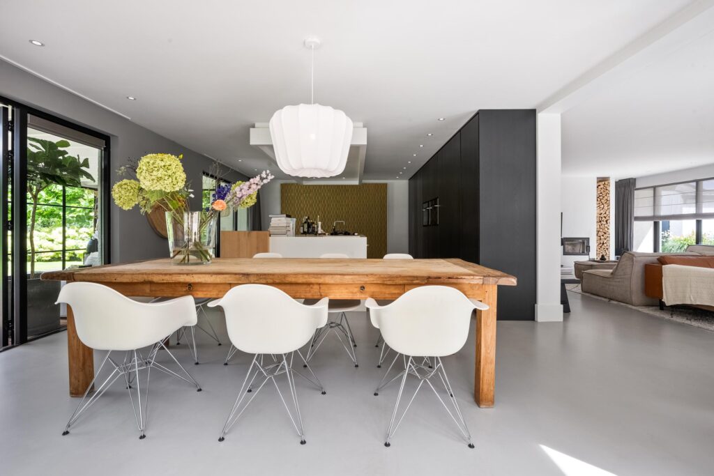 Modern dining room with wooden table and white chairs.