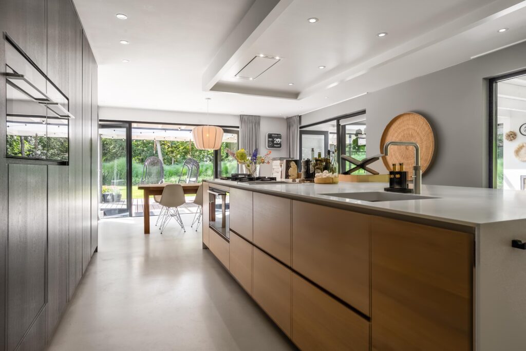 Modern kitchen with island and large windows.