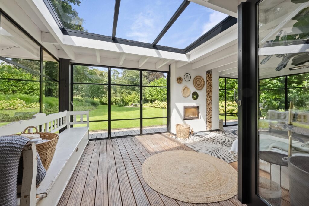 Bright sunroom with garden view and cozy decor.