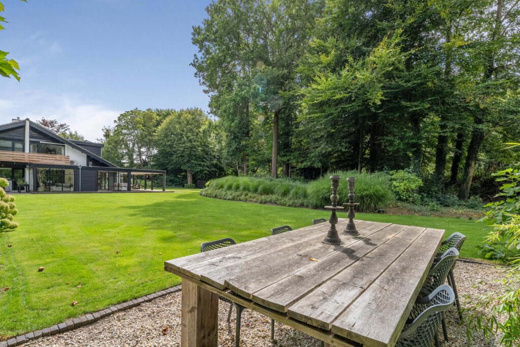 Spacious backyard with forest view and wooden table