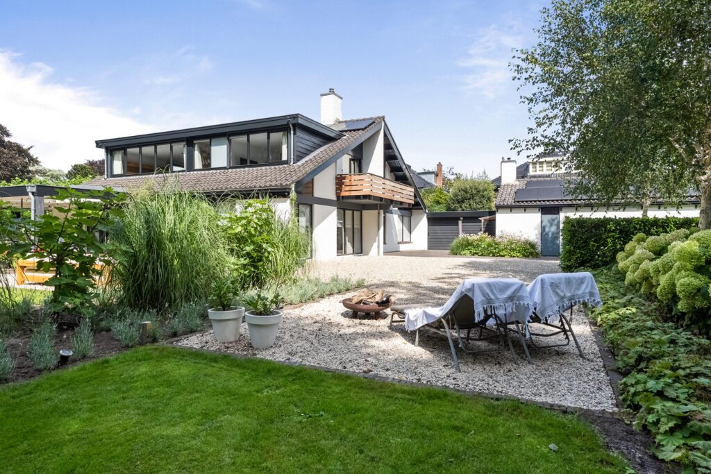 Modern house with garden and patio seating.