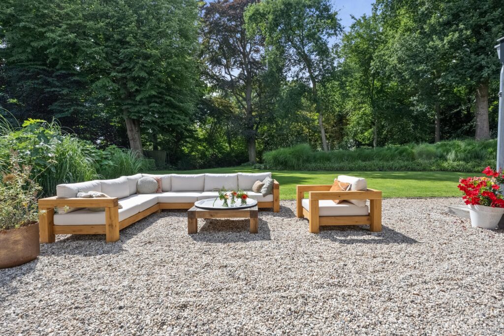 Outdoor seating area with green garden backdrop.