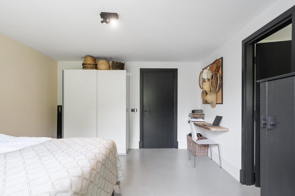 Minimalist bedroom with desk and storage baskets.