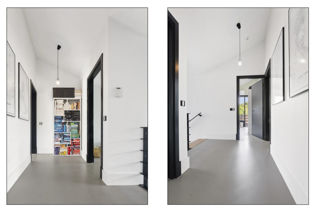 Modern hallway with bookshelves and framed maps.