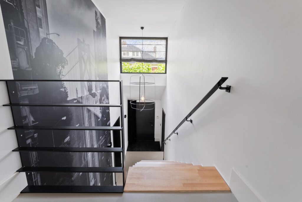 Modern staircase with wall art and pendant light.