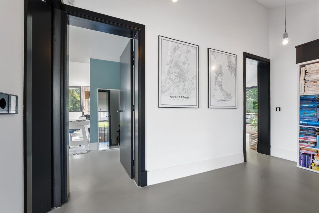 Modern hallway with open doors and city maps.