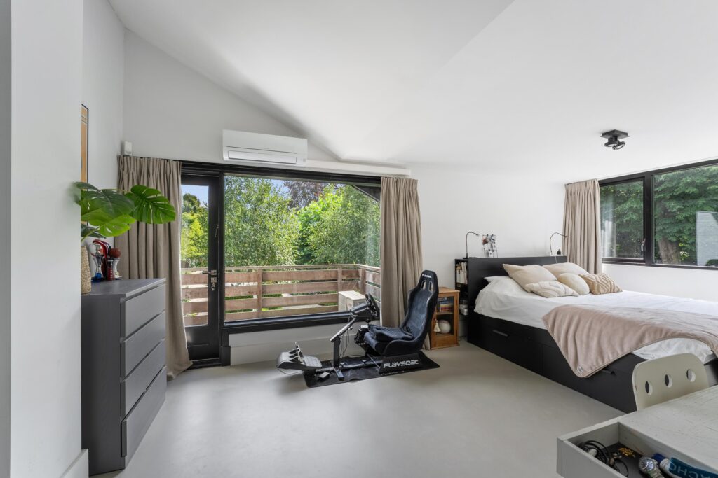 Modern bedroom with balcony and gaming chair