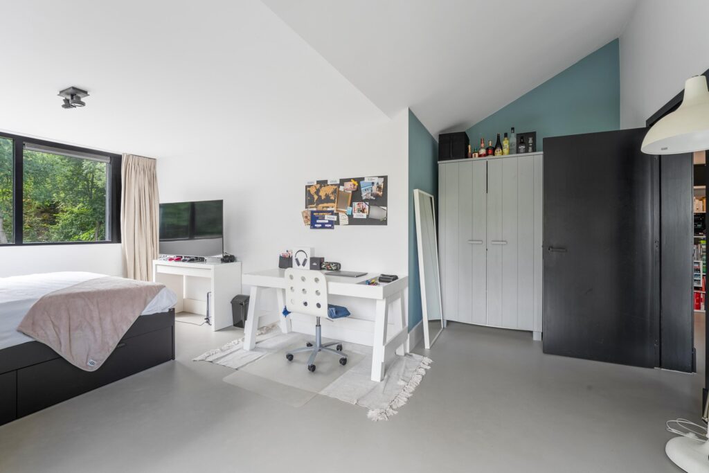 Modern bedroom with desk and natural light.