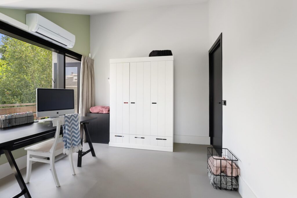 Modern room with desk, chair, wardrobe, and window