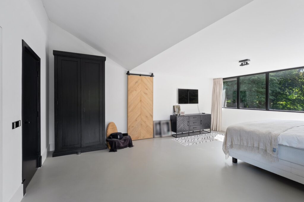 Modern bedroom with minimalist decor and large window.