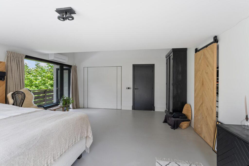 Modern bedroom with large window and minimalist decor.