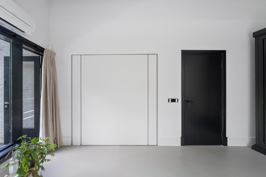 Minimalist room with black door and window.