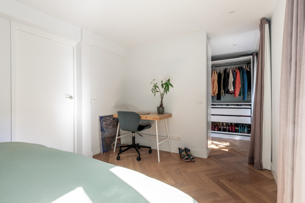 Minimalist bedroom with desk and open closet