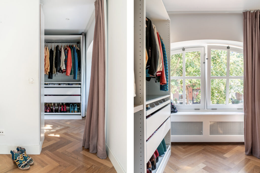 Open closet with clothes and shoes near window.